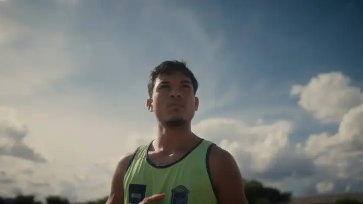 Rapaz de regata verde olhando para o céu