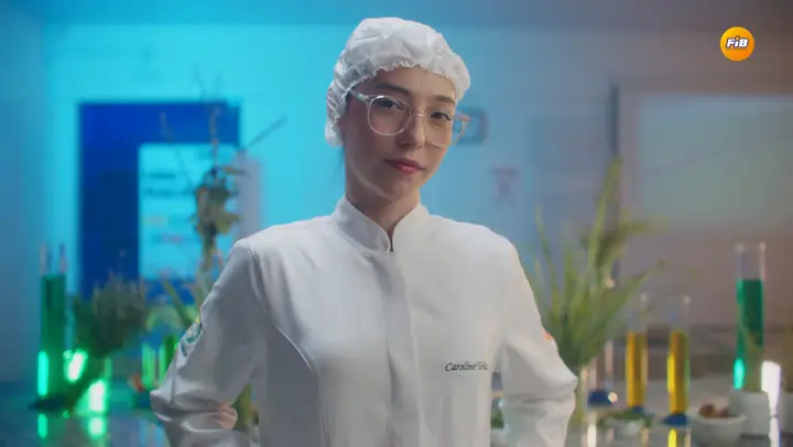 Pesquisadora de jaleco e touca no laboratório